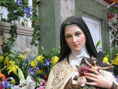 Statue de Sainte Thérèse de Lisieux et fleurs