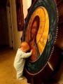 Pieux Bébé touchant une icône de Jésus