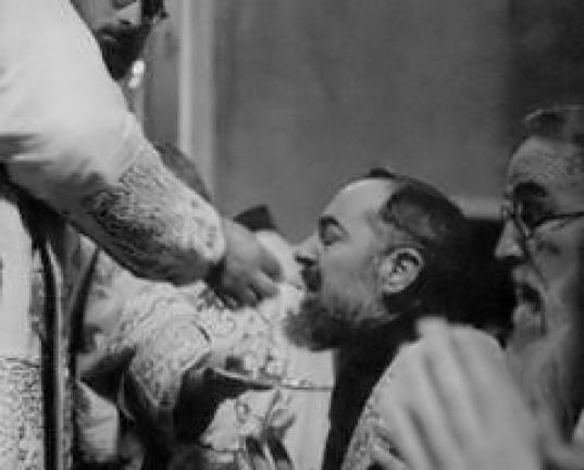Saint Padre Pio commmuniant à genoux